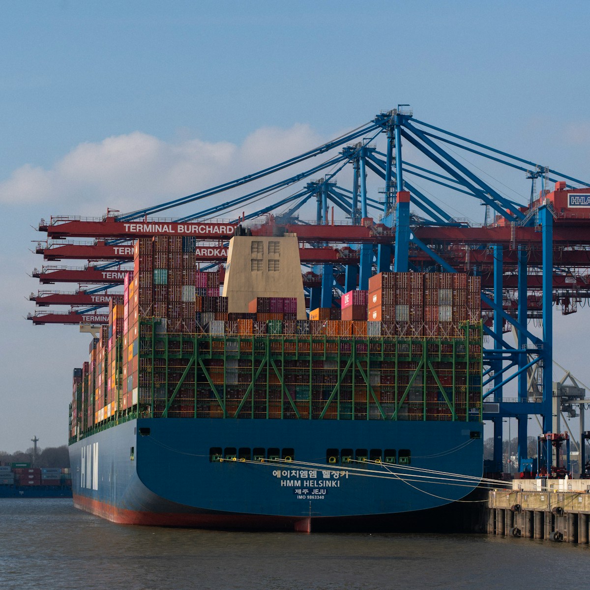 A cargo ship is being unloaded at the harbor.